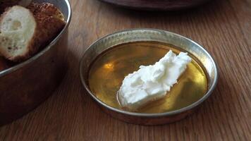 butter cream and honey in a bowl on table . video