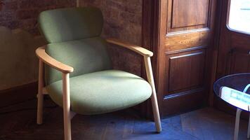 a green chair placed next to a window video