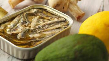 open tin of sardines on white tiles background. video