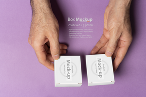 Male hand holding two pills box for compairing in front of purple background mock-up series psd