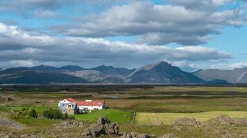 Clouds move over the mountains in Iceland. Farm on the plain. Time lapse. Zoom out. video