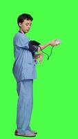 profil medicinsk assistent som visar tonometer Begagnade till mäta arteriell blod tryck, stående mot grönskärm bakgrund. sjuksköterska arbetssätt med sphygmomanometer verktyg till ta mått på kolla upp. kamera a. video
