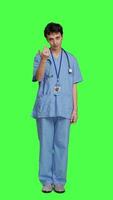 Front view Medical assistant asking a person to come over closer against greenscreen backdrop, inviting patient to approach. Nurse in scrubs calling someone at checkup examination, young surgeon. Camera A. video