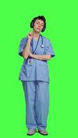 Front view Cheerful health specialist listening to cool music on audio headset, dancing against greenscreen backdrop and having fun. Nurse enjoying songs an doing funny dance moves, leisure. Camera A. video