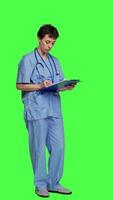 Side view Medical specialist examines x ray scan in hospital laboratory, looking at radiography to determine patient disease diagnosis. Nurse uses radiology expertise against greenscreen backdrop. Camera A. video