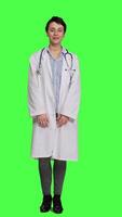 Front view Portrait of physician wearing a white coat and a stethoscope for exams, standing against greenscreen backdrop. Doctor specialist working in healthcare industry, medical expertise. Camera A. video