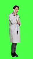 Side view Physician answering landline phone call against greenscreen backdrop, talking to patients about checkup appointments. Medic having remote discussion on retro telephone with cord. Camera A. video