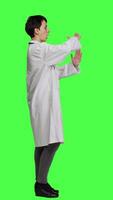 Profile Woman physician doing timeout gesture against greenscreen backdrop, asking for a work break after multiple examinations. Doctor showing pause or stop symbol, feeling tired. Camera A. video