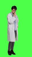 Side view General practitioner thinking about new healthcare ideas in studio, acting pensive against greenscreen backdrop. Woman medic contemplating about ways to find disease cures. Camera A. video