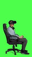 profil kvinna spelar video spel använder sig av virtuell verklighet headsetet i studio, njuter cyberrymden 3d gaming turnering mot grönskärm bakgrund. gamer har roligt med vr glasögon. kamera a.