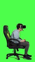 Profil Frau spielen Video Spiele auf Konsole mit Regler und vr Headset, Sitzung gegen grüner Bildschirm Hintergrund. Spieler haben Spaß mit online Turnier, virtuell Wirklichkeit interaktiv Cyberspace. Kamera a.