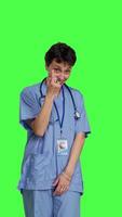 Front view Medical assistant asking a person to come over closer against greenscreen backdrop, inviting patient to approach. Nurse in scrubs calling someone at checkup examination, young surgeon. Camera B. video