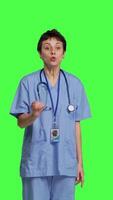 Front view Stressed furious nurse screaming at someone against greenscreen backdrop, showing rage and anger in studio. Aggressive upset medical assistant shouting and being dissatisfied. Camera B. video