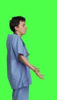 Profile Medical assistant shrugging and doing i dont know sign in studio, acting clueless and uncertain against greenscreen backdrop. Nurse in scrubs gesticulating doubtful reaction, unsure girl. Camera B. video