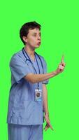 sida se missnöjd irriterad sjuksköterska skrikande Nej och argumenterar med någon mot grönskärm bakgrund, som visar rasa och ilska medan hon bär sjukhus skrubbar. aggressiv medicinsk assistent. kamera b. video