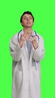 Front view Angry physician yelling at people and being aggressive in studio, getting mad and furious at something against greenscreen backdrop. Irritated annoyed medic screaming, being displeased. Camera B. video