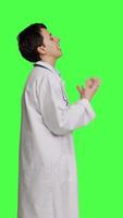 Profile Angry physician yelling at people and being aggressive in studio, getting mad and furious at something against greenscreen backdrop. Irritated annoyed medic screaming, being displeased. Camera B. video