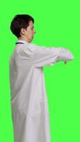 Profile Displeased physician showing thumbs down symbol against greenscreen backdrop, expresses negativity and rejection. Doctor feeling dissatisfied and disagreeing with an idea, dislike sign. Camera B. video