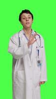 Front view Woman health specialist showing no sign and being furious against greenscreen backdrop, expressing negativity and rage in studio. Angry physician screaming and shouting at people. Camera B. video