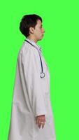 Profile Physician being uncertain about something in studio, shrugging and feeling clueless about the right answer. Doctor doing i dont know symbol against greenscreen backdrop, confusion. Camera B. video