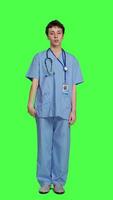 Front view Health specialist with blue scrubs showing stop sign in studio, standing against greenscreen backdrop. Nurse expressing denial and refusal with warning forbidden symbol, denying something. Camera A. video