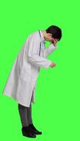 Profil unzufrieden Medizin Umgang mit ein schmerzlich Migräne gegen grüner Bildschirm Hintergrund, Arbeiten im Gesundheitswesen Industrie unter Druck. Frau Arzt Leiden von ein Kopfschmerzen, überarbeitet. Kamera a. video