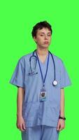 Front view Displeased nurse saying no and sighing against greenscreen backdrop, acting disappointed while she wears blue scrubs. Medical assistant with expertise shows negative gesture, being tired. Camera B. video