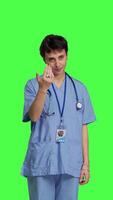 Front view Medical assistant asking a person to come over closer against greenscreen backdrop, inviting patient to approach. Nurse in scrubs calling someone at checkup examination, young surgeon. Camera B. video