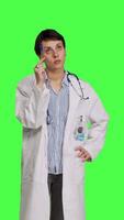 Front view General practitioner thinking about new healthcare ideas in studio, acting pensive against greenscreen backdrop. Woman medic contemplating about ways to find disease cures. Camera B. video