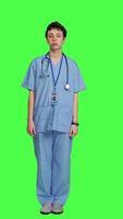 Front view Displeased nurse saying no and sighing against greenscreen backdrop, acting disappointed while she wears blue scrubs. Medical assistant with expertise shows negative gesture, being tired. Camera A. video