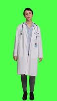 Front view Portrait of physician wearing a white coat and a stethoscope for exams, standing against greenscreen backdrop. Doctor specialist working in healthcare industry, medical expertise. Camera A. video