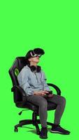 Side view Woman playing video games using virtual reality headset in studio, enjoying cyberspace 3d gaming tournament against greenscreen backdrop. Gamer having fun with vr glasses. Camera A.