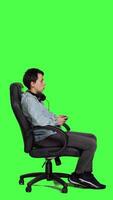 Profile Woman gamer playing online video games with controller, sitting in an office chair against greenscreen backdrop. Joyful person having fun with e sport competition, modern gaming setup. Camera A.