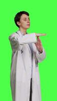 Side view Woman physician doing timeout gesture against greenscreen backdrop, asking for a work break after multiple examinations. Doctor showing pause or stop symbol, feeling tired. Camera B. video