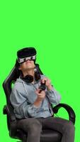 Front view Gamer losing at video games with virtual reality headset and controller, connecting online with her friends to play multiplayer championship. Woman gaming against greenscreen backdrop. Camera B.