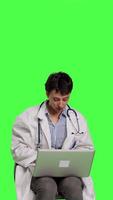 Front view Physician doing research with a x ray scan result against greenscreen backdrop, examining radiography diagnosis to help patients with disease. Woman doctor studying radiology in studio. Camera B. video