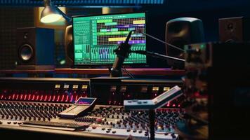 Music recording studio control room with daw software used to mix and master audio tracks, empty soundproof professional space. Modern sliders on control panel board to edit sound waves. video