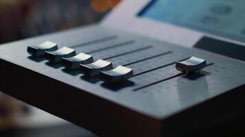 geluid ingenieur in werking Aan gemotoriseerd faders controleur in professioneel studio, bewerken en menging sporen naar creëren een liedje. audio technicus werken met schuifregelaars en klankbord paneel. camera a. video