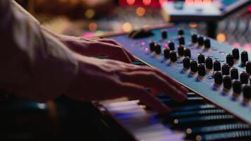 Jeune chanteur en jouant piano électronique clavier dans contrôle chambre, enregistrement Nouveau la musique avec midi manette et mélange console. talentueux compositeur pratiquant sur synthétiseur dans studio. caméra un. video