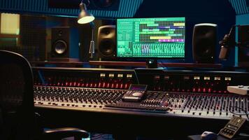 Empty control room professional studio used in music recording industry, mixing console and post production equipment. Soundproof space with daw software, faders and audio editing tools. video