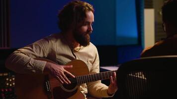 experto compositor productor y grabación nuevo pista en guitarra, creando un En Vivo actuación en controlar habitación. compositor de canciones artista composición música para su nuevo álbum. cerca arriba. cámara una. video