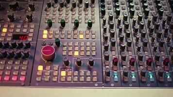 Pre amp knobs and switchers on mixing console panel board, audio stereo equipment used in music post production. Empty control room in professional studio, fader and sliders. Close up. video