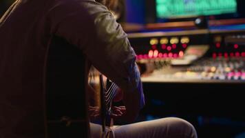 talentueux guitariste Faire vivre performance dans professionnel studio, enregistrement Nouveau des pistes sur mélange console amplificateur. Jeune artiste musicien performant Nouveau Chansons, créer musique. caméra un. video