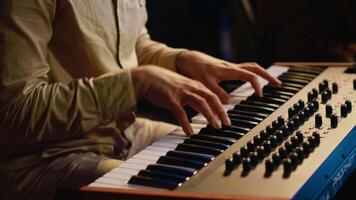 zanger performer creëren een lied Aan piano midi controleur in studio, opname aantekeningen Aan elektronisch toetsenbord. artiest musicus componeren en produceren sporen met technicus. camera a. video