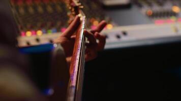 Musician singer recording a new song on his electro acoustic guitar, creating new music in professional studio control room. Artist doing live performance with instrument. Close up. Camera A. video