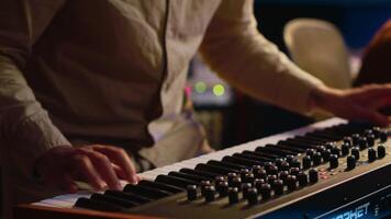 musicus componist spelen midi controleur synthesizer in professioneel studio, componeren muziek- Aan menging troosten. artiest het uitvoeren van Aan piano elektronisch toetsenbord in controle kamer. camera a. video