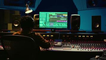 Audio designer leveling sound on a mixer control desk, professional music studio concept. Producer turns up volume and adding effects on a mixing console, recording live tracks. Camera B. video