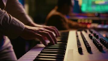 musicien compositeur en jouant midi manette synthétiseur dans professionnel studio, composition la musique sur mélange console. artiste performant sur piano électronique clavier dans contrôle chambre. caméra b. video