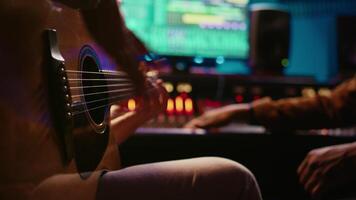 experto compositor productor y grabación nuevo pista en guitarra, creando un En Vivo actuación en controlar habitación. compositor de canciones artista composición música para su nuevo álbum. cerca arriba. cámara b. video