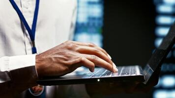 IT developer using laptop to examine server mainframes providing vast computing resources and storage, enabling artificial intelligence to process massive datasets for training and inference, close up photo